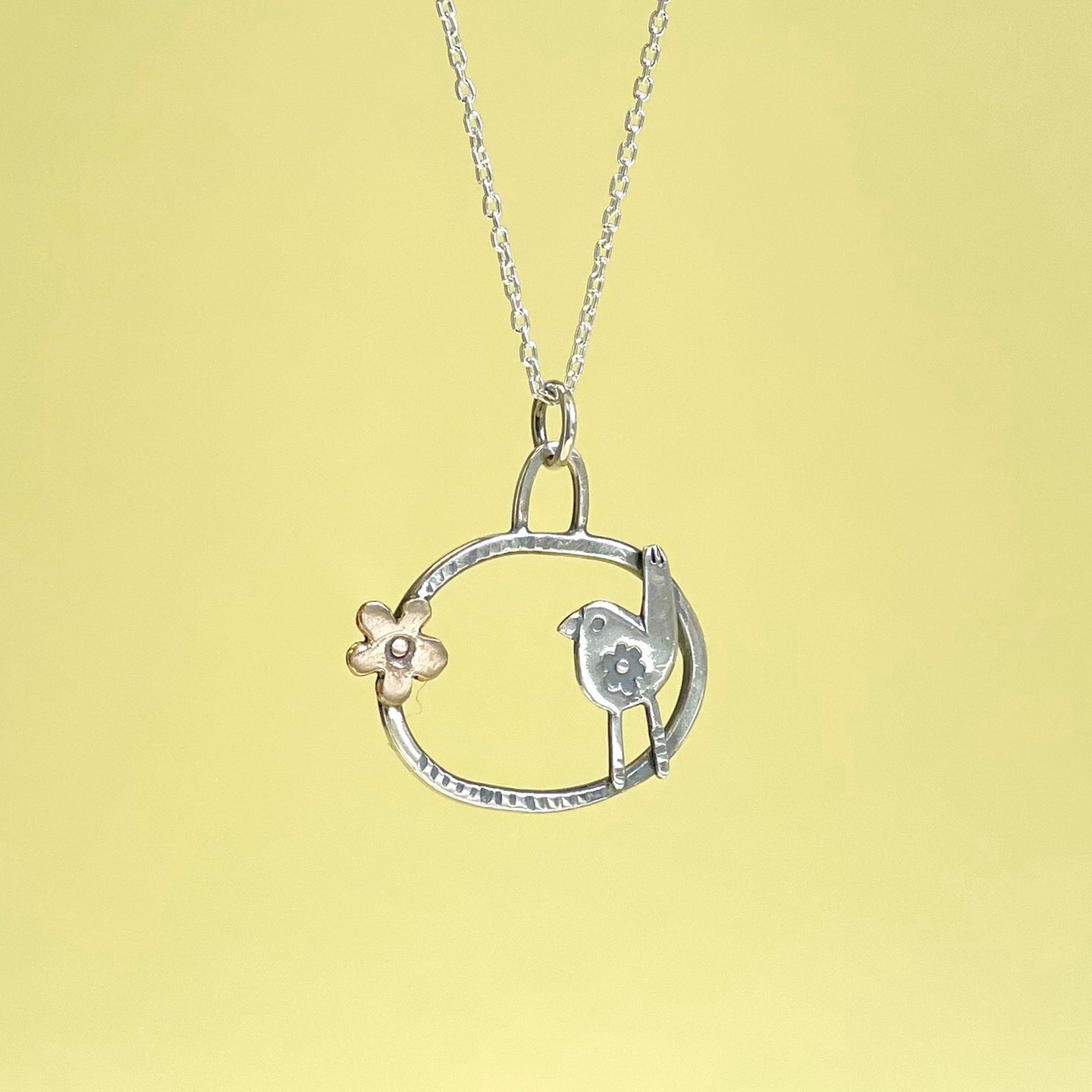Bronze flower and silver bird hoop pendant