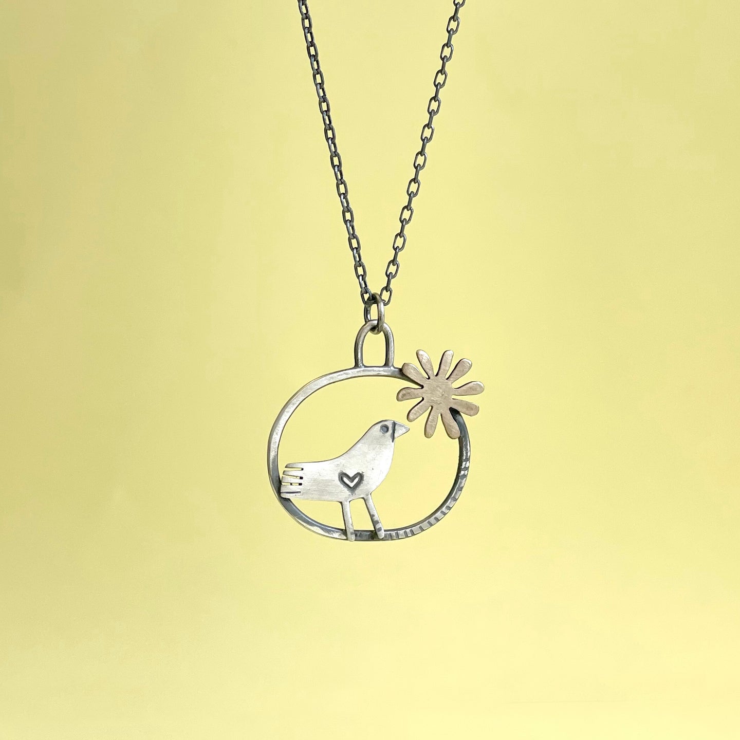 Silver bird in hoop with bronze flower pendant 2