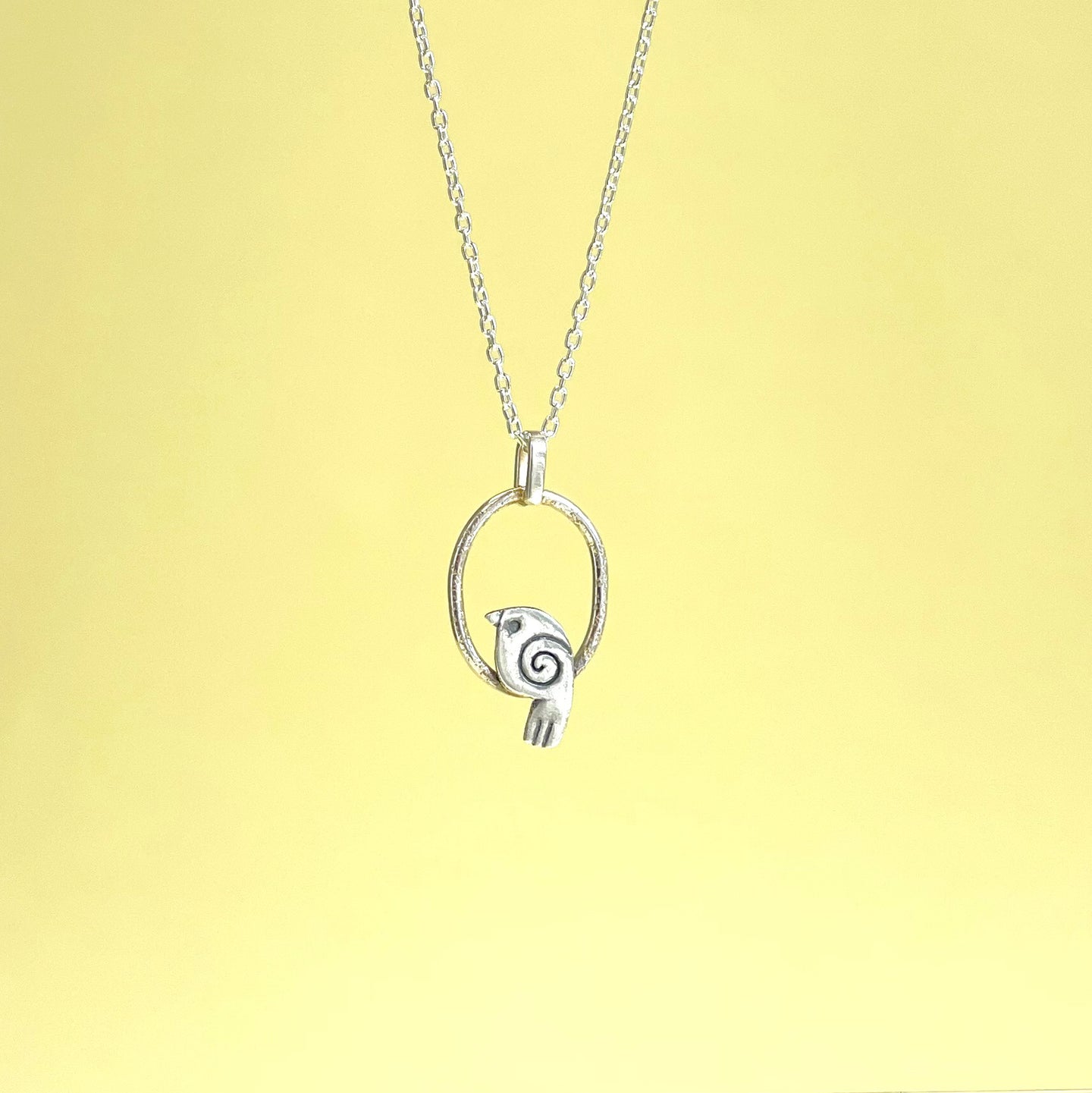Silver bird in hoop pendant