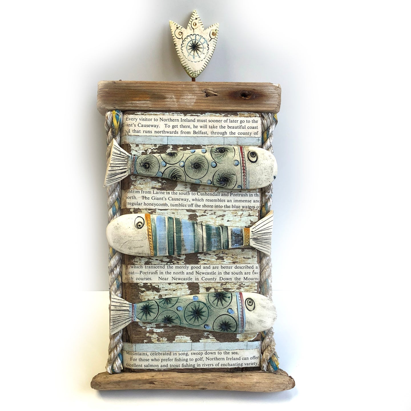 Ceramic fishes on wooden plaque